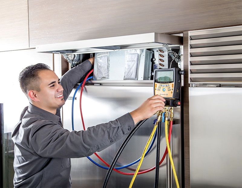Service tech checks refrigerator components